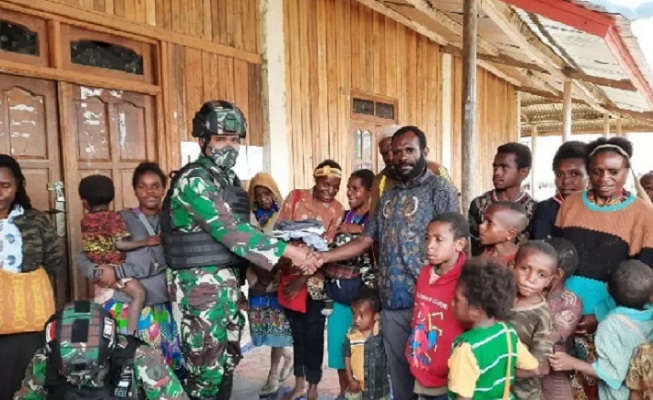 Personel Satgas Pamrahwan Yonif Mekanis 521DY membagikan pakaian layak pakai untuk warga asli Papua di kampung Obano Kabupaten Paniai.