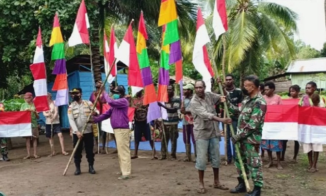 Personel TNIPolri bersama tokoh masyarakat Kampung Yakyu, Distrik Sota, Kabupaten Merauke, Papua mengibarkan bendera merah putih di perbatasan RI-PNG
